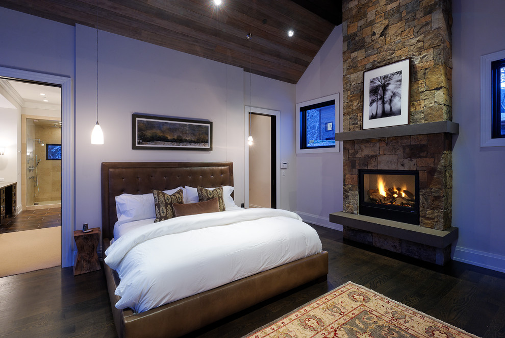 This is an example of a country bedroom in Denver with a stone fireplace surround and a standard fireplace.