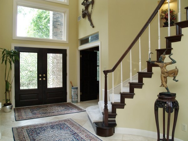 Photo of a large traditional front door in Cleveland with beige walls, limestone floors, a double front door, a black front door and beige floor.