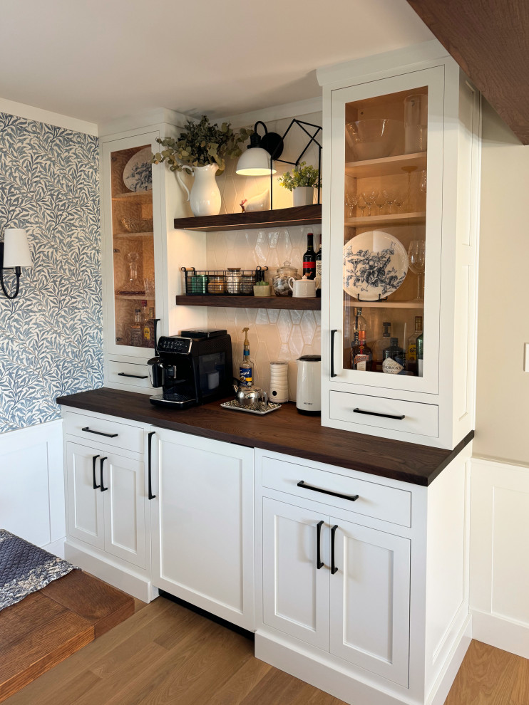 Mid-sized transitional l-shaped medium tone wood floor and brown floor eat-in kitchen photo with an undermount sink, shaker cabinets, white cabinets, white backsplash, an island and brown countertops