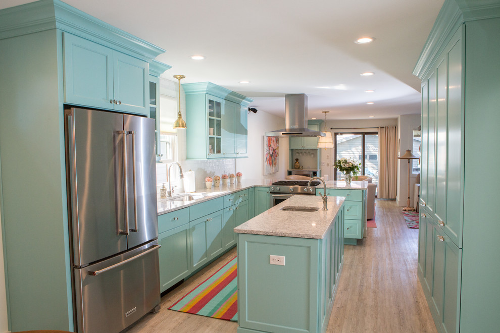 This is an example of a small beach style l-shaped eat-in kitchen in Other with an undermount sink, flat-panel cabinets, turquoise cabinets, quartz benchtops, white splashback, ceramic splashback, stainless steel appliances, vinyl floors, with island and grey floor.