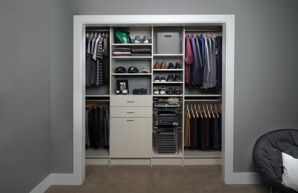 This is an example of a contemporary men's built-in wardrobe in Orange County with flat-panel cabinets and carpet.