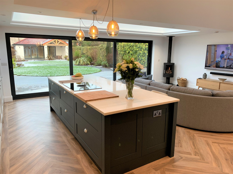 Inspiration for a large classic single-wall open plan kitchen in Other with a single-bowl sink, shaker cabinets, medium wood cabinets, quartz worktops, glass sheet splashback, black appliances, vinyl flooring, an island and white worktops.