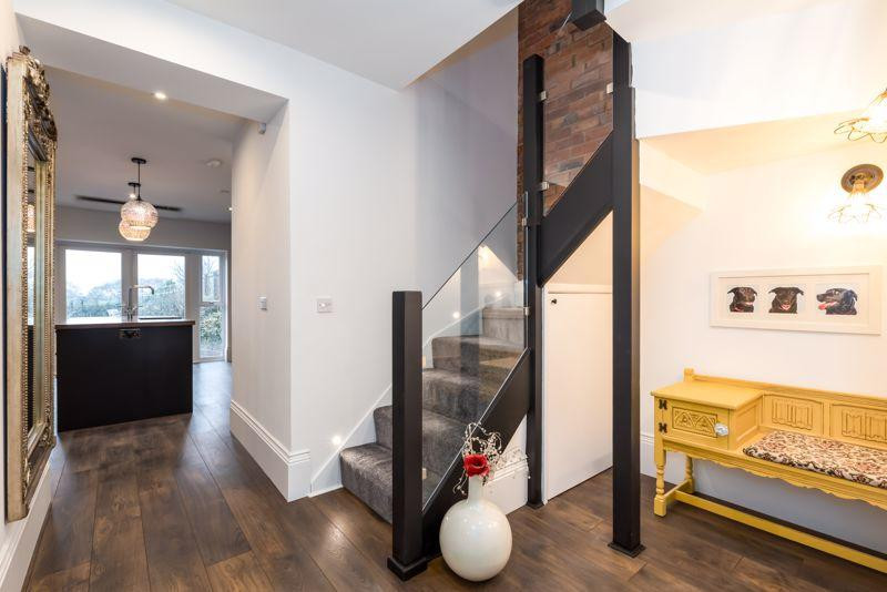 На фото: угловая лестница среднего размера в стиле модернизм с ступенями с ковровым покрытием, стеклянными перилами и кирпичными стенами с