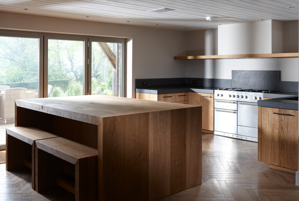 Design ideas for an expansive arts and crafts u-shaped eat-in kitchen in Sydney with an undermount sink, flat-panel cabinets, medium wood cabinets, black splashback, stainless steel appliances, medium hardwood floors, with island, concrete benchtops and cement tile splashback.