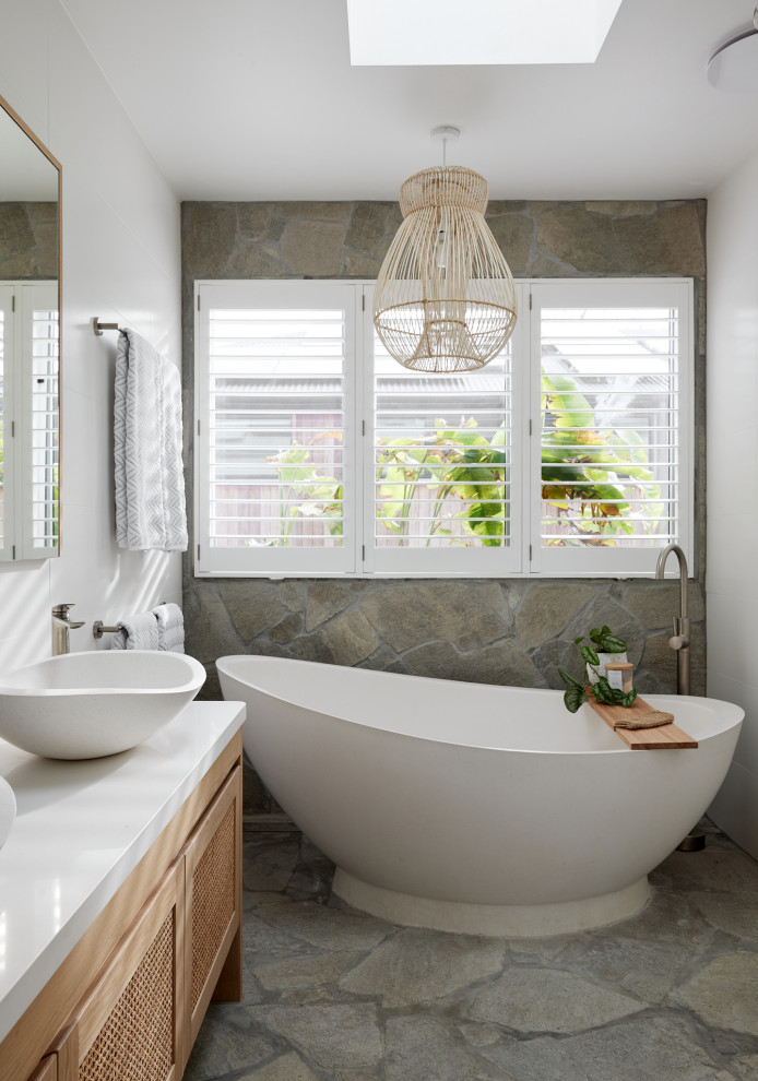 Beach style bathroom in Other with recessed-panel cabinets, light wood cabinets, a freestanding bath, white tiles, a vessel sink, white worktops, double sinks and a freestanding vanity unit.
