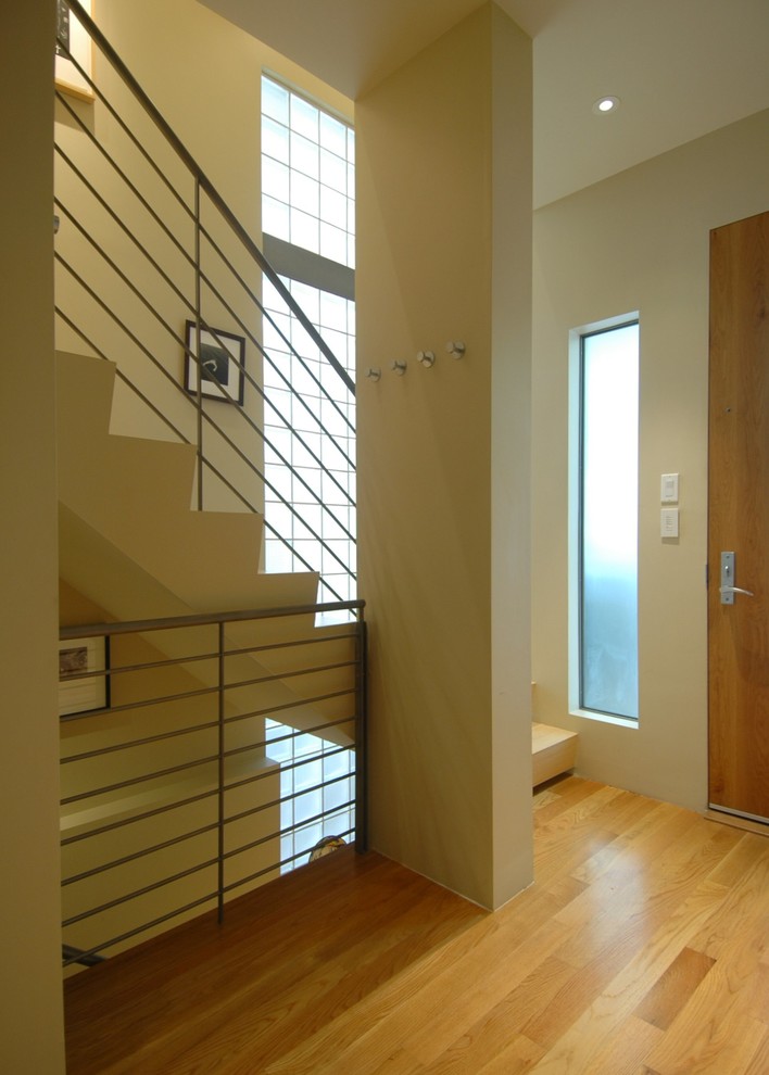 This is an example of a mid-sized modern foyer in San Francisco with yellow walls, bamboo floors, a single front door and a light wood front door.