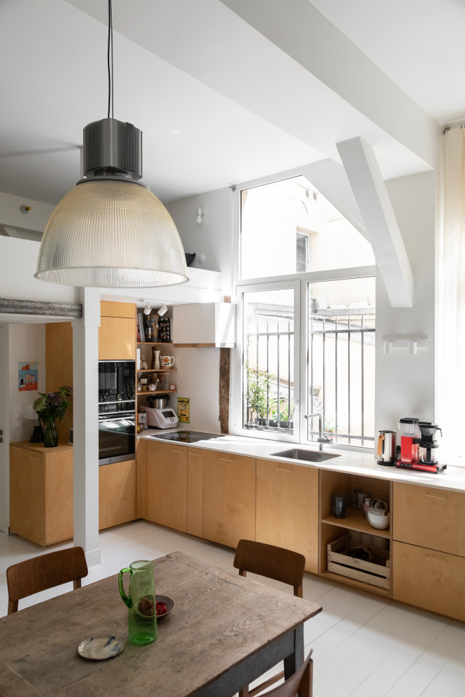 Свежая идея для дизайна: угловая кухня-гостиная в белых тонах с отделкой деревом в стиле модернизм с одинарной мойкой, деревянным полом, бежевой столешницей и мойкой у окна - отличное фото интерьера