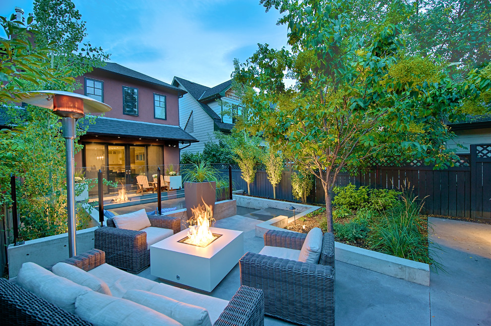 Photo of a mid-sized contemporary backyard patio in Calgary with a fire feature, no cover and concrete slab.