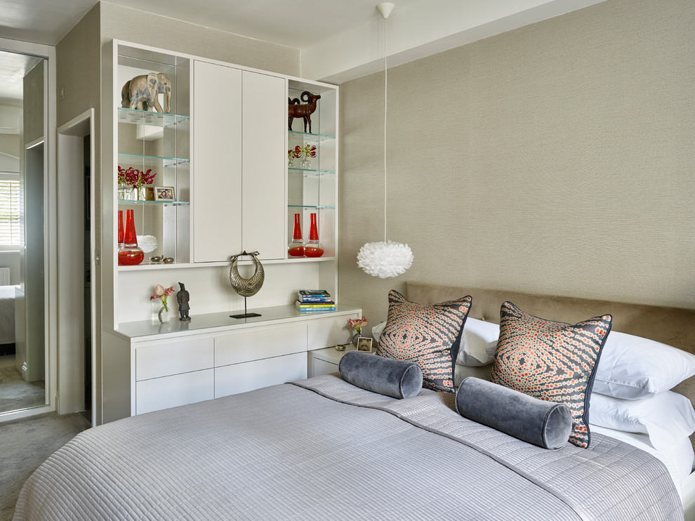 This is an example of a contemporary master bedroom in London with carpet, white walls and grey floor.