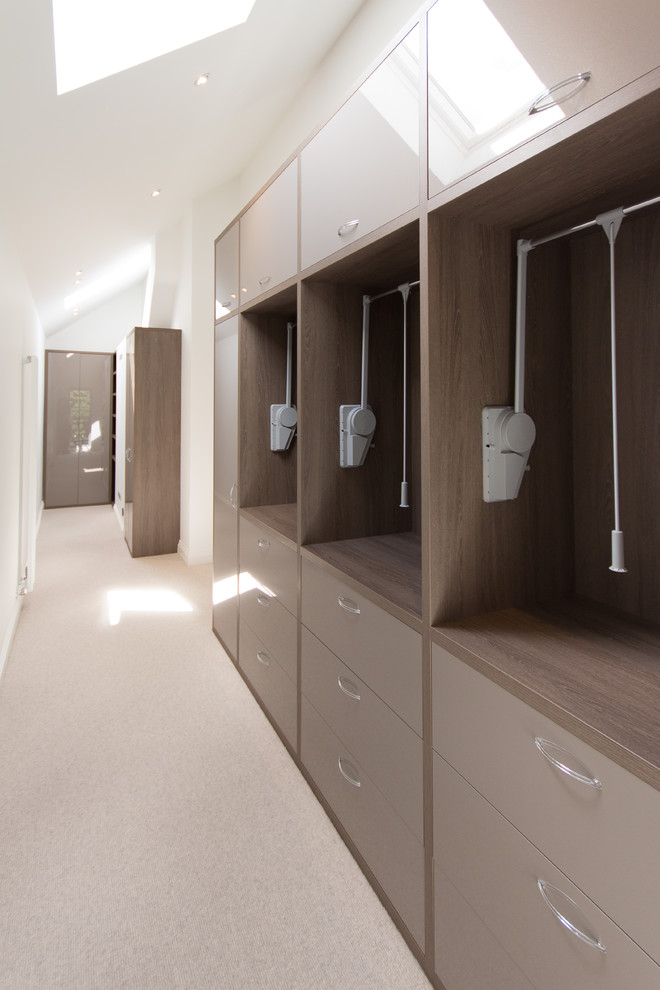 Design ideas for a large modern storage and wardrobe in London with carpet and beige floor.