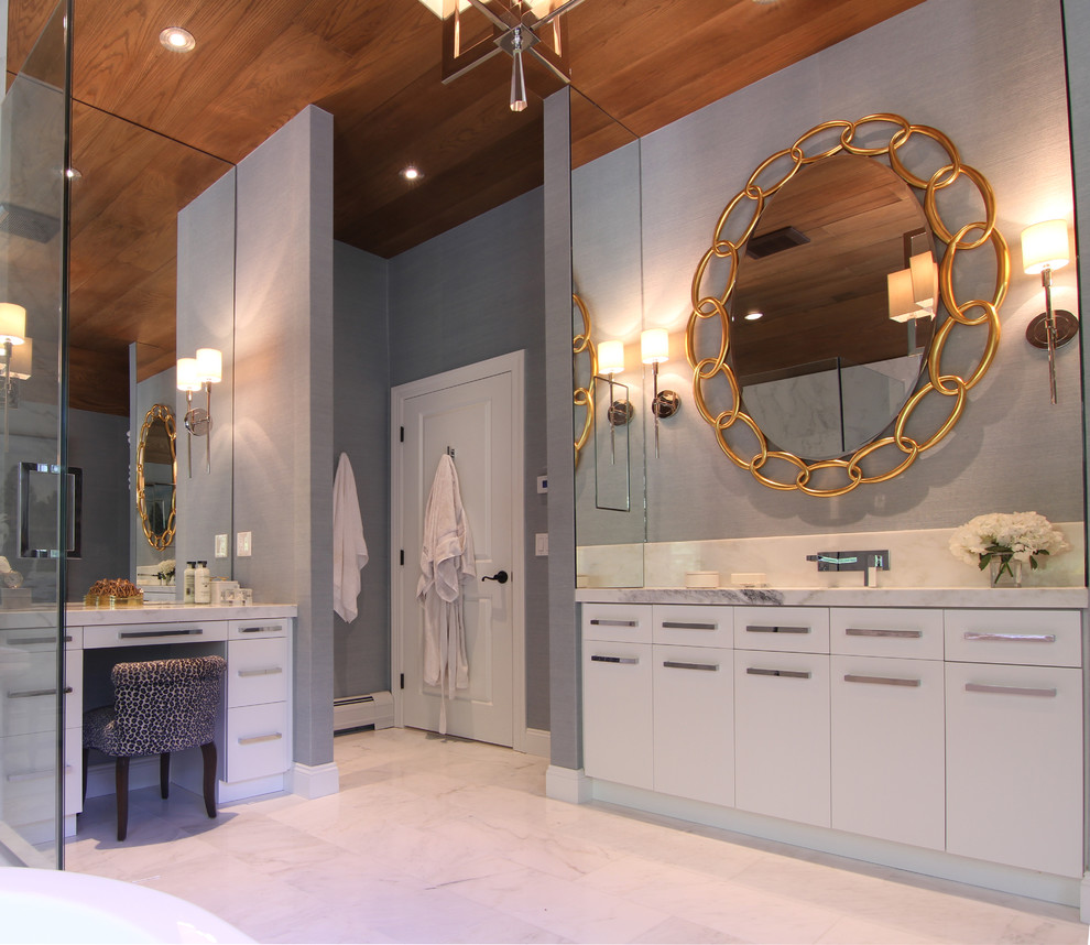 This is an example of a large transitional master bathroom in New York with flat-panel cabinets, white cabinets, white tile, gray tile, a freestanding tub, a corner shower, stone slab, grey walls, marble floors, marble benchtops and a hinged shower door.