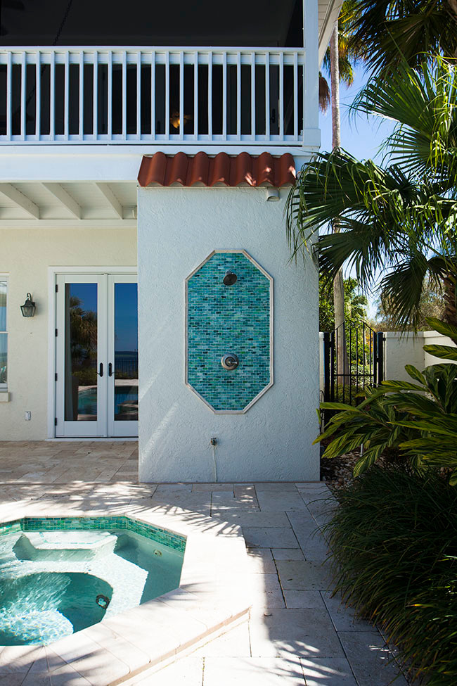 This is an example of a mid-sized mediterranean backyard custom-shaped pool in Tampa with a hot tub.