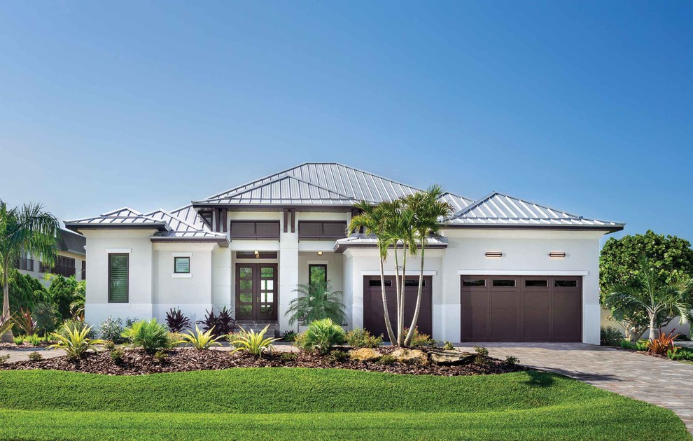 This is an example of a beach style grey house exterior in Other with a hip roof and a metal roof.