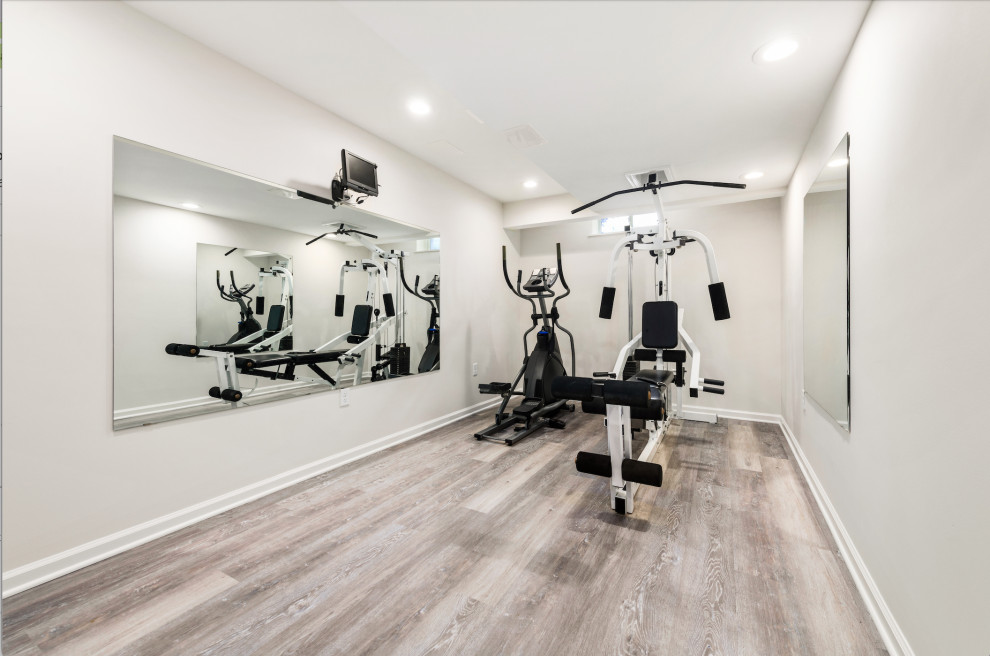 Design ideas for a mid-sized traditional home weight room in Philadelphia with grey walls, laminate floors and brown floor.