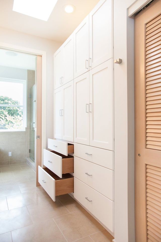 Inspiration for a small modern gender-neutral storage and wardrobe in Hawaii with shaker cabinets, white cabinets and porcelain floors.
