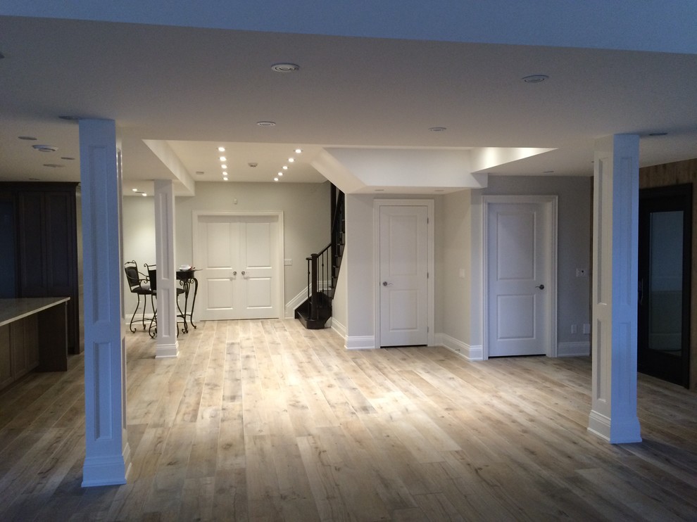 Inspiration for a large transitional underground light wood floor and beige floor basement remodel in Toronto with gray walls and no fireplace