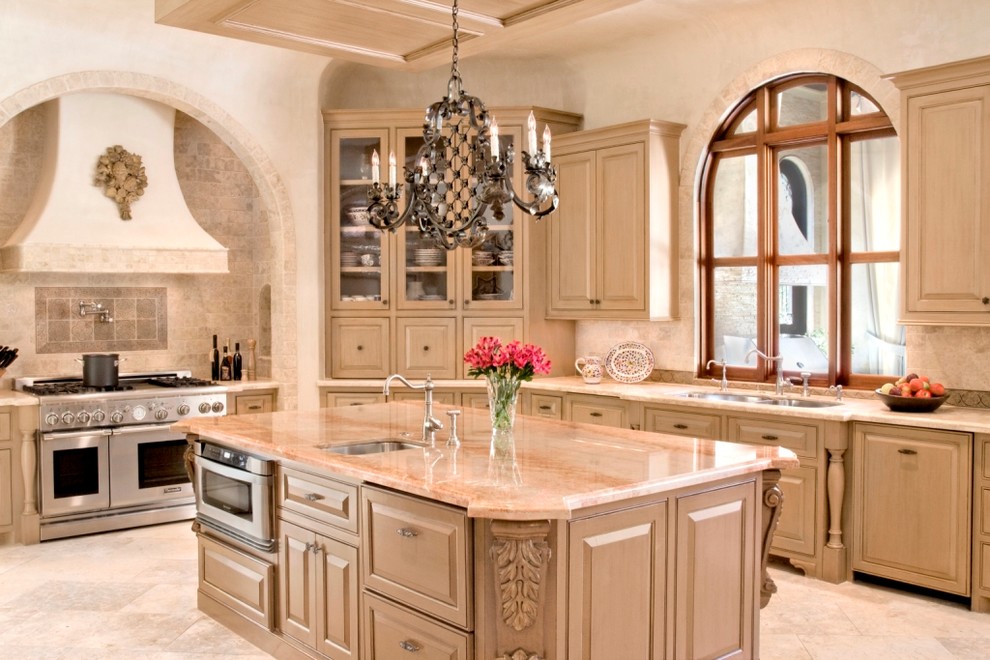 Inspiration for an expansive traditional u-shaped open plan kitchen in Houston with an undermount sink, raised-panel cabinets, stainless steel appliances, travertine floors, with island, beige cabinets, granite benchtops, beige splashback and mosaic tile splashback.