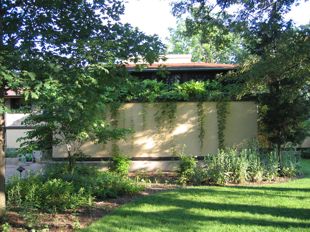 Photo of a mid-sized arts and crafts front yard shaded garden for summer in Chicago with a container garden and mulch.