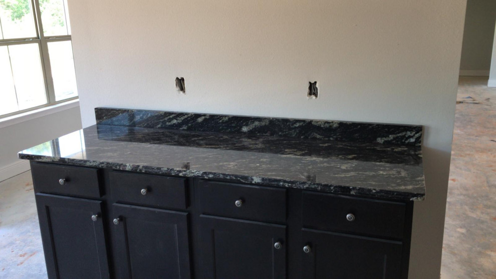 Mid-sized kitchen photo with black cabinets, granite countertops, stainless steel appliances and black countertops