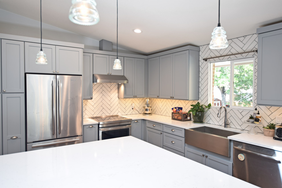 Open concept kitchen - mid-sized transitional l-shaped vaulted ceiling open concept kitchen idea in Denver with a farmhouse sink, shaker cabinets, gray cabinets, quartz countertops, white backsplash, stainless steel appliances, an island and white countertops