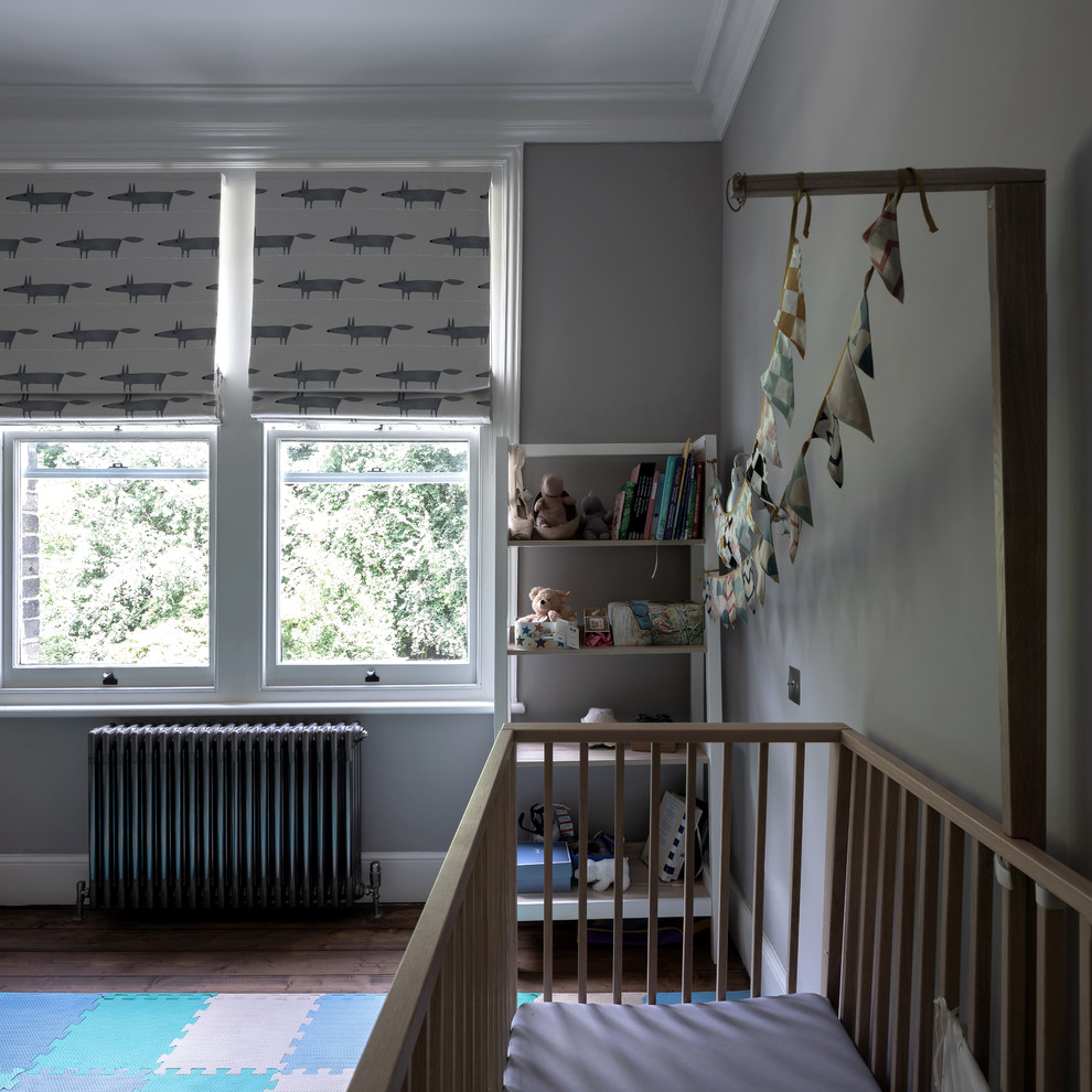 Design ideas for a mid-sized traditional gender-neutral nursery in London with beige walls, medium hardwood floors and brown floor.