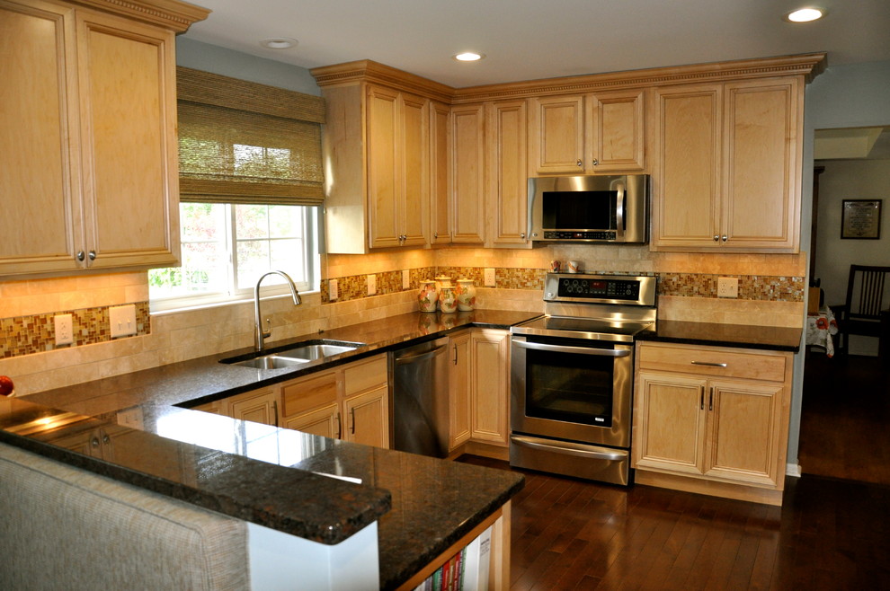 This is an example of a mid-sized transitional single-wall eat-in kitchen in Cincinnati with an undermount sink, shaker cabinets, light wood cabinets, granite benchtops, beige splashback, mosaic tile splashback, stainless steel appliances and dark hardwood floors.