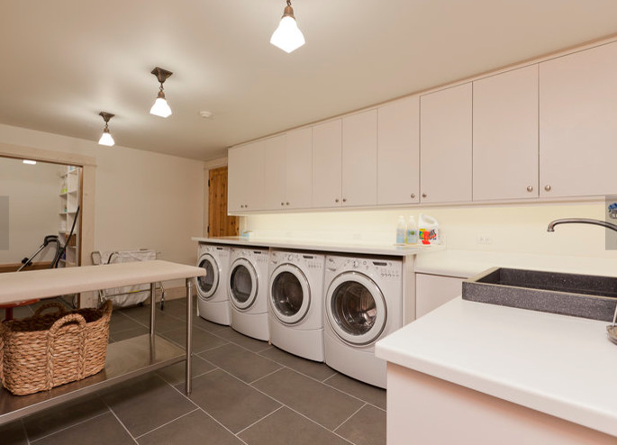 Huge elegant l-shaped slate floor and gray floor utility room photo in Denver with a drop-in sink, flat-panel cabinets, white cabinets, laminate countertops, white walls and a side-by-side washer/dryer