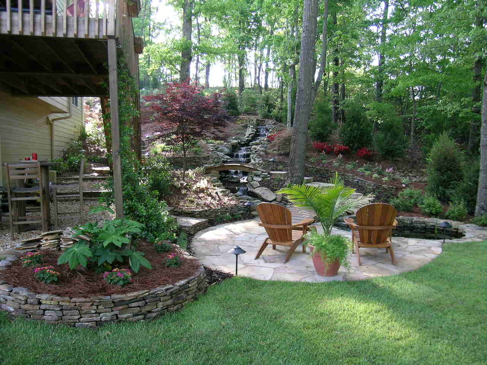 Design ideas for a large asian sloped partial sun garden in Atlanta with a retaining wall and natural stone pavers.