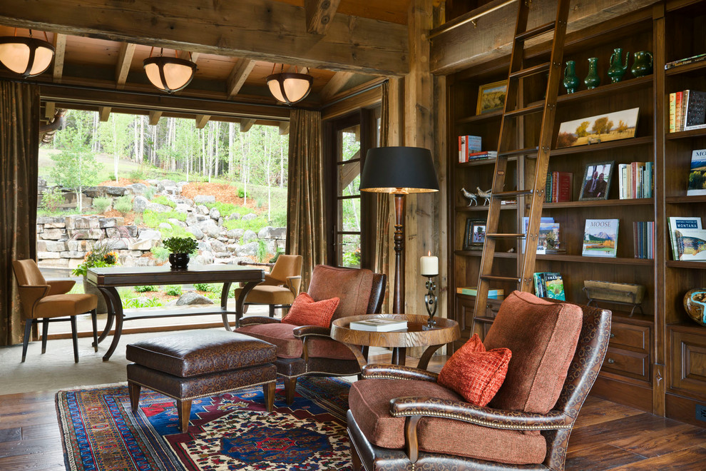Country living room in Other with a library and dark hardwood floors.