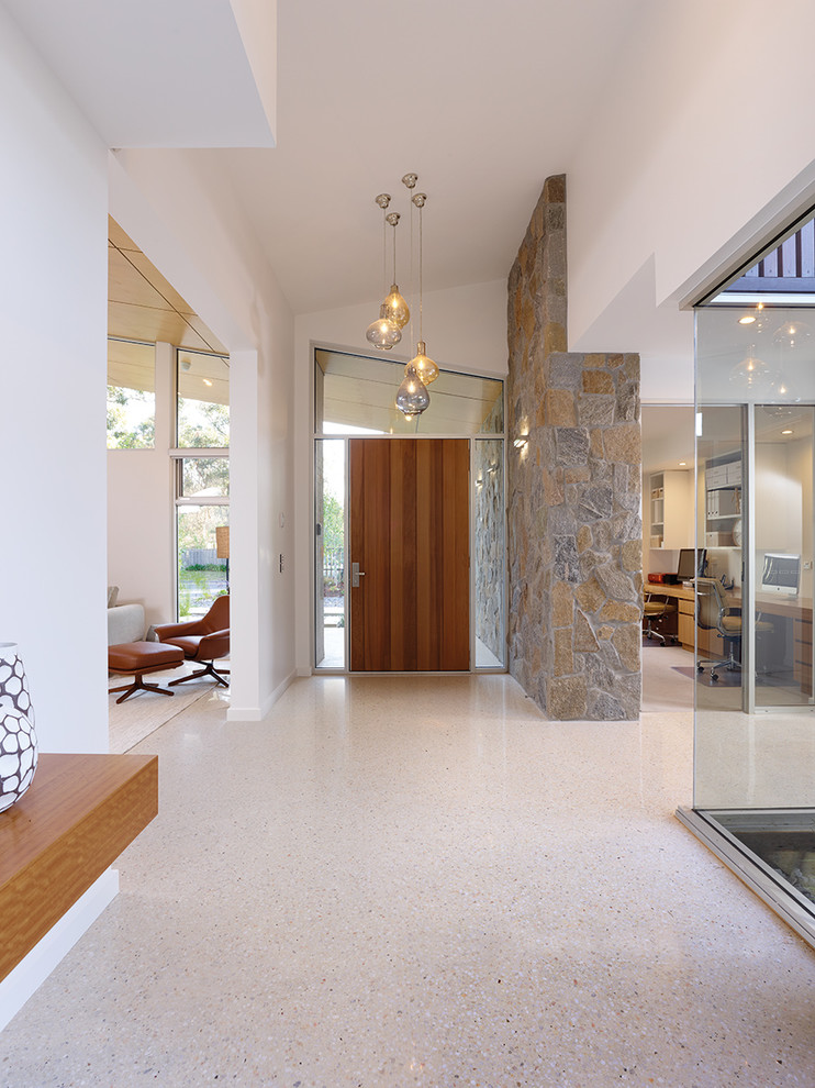 Photo of a large contemporary hallway in Melbourne with white walls and concrete floors.
