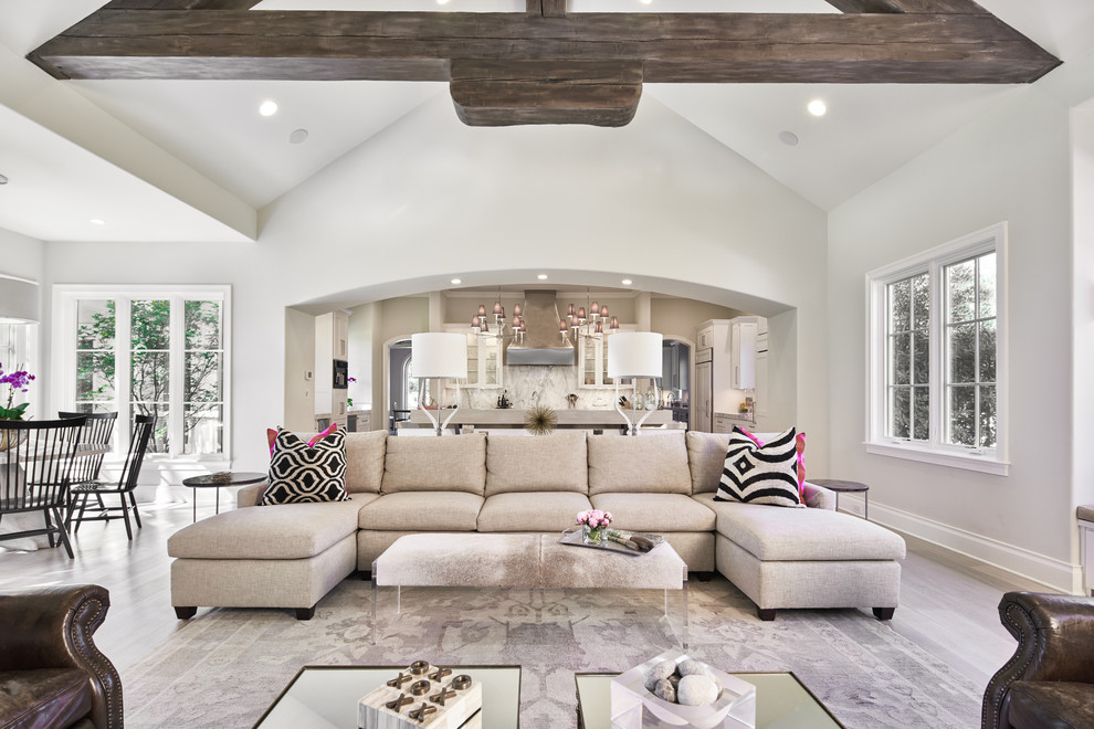 This is an example of an expansive transitional open concept living room in Austin with grey walls, a standard fireplace and medium hardwood floors.