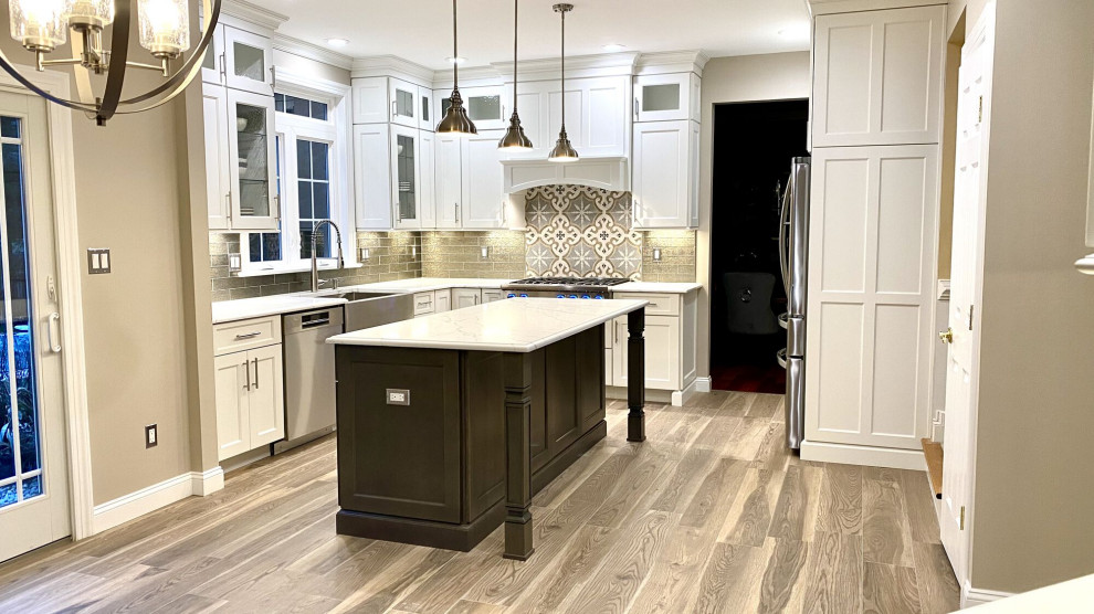 Inredning av ett modernt stort flerfärgad flerfärgat kök, med en rustik diskho, skåp i shakerstil, vita skåp, bänkskiva i kvarts, grått stänkskydd, stänkskydd i glaskakel, rostfria vitvaror, ljust trägolv, en köksö och grått golv