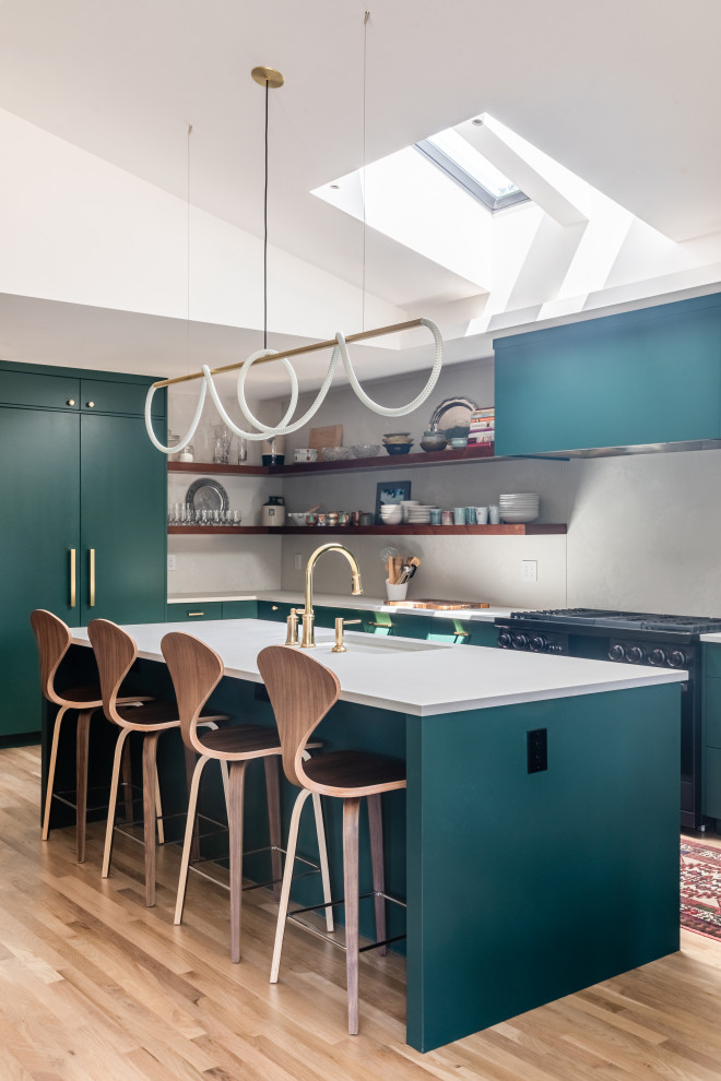 Example of a mid-sized trendy single-wall light wood floor, beige floor and vaulted ceiling open concept kitchen design in Denver with an undermount sink, flat-panel cabinets, green cabinets, quartz countertops, yellow backsplash, quartz backsplash, black appliances, an island and white countertops