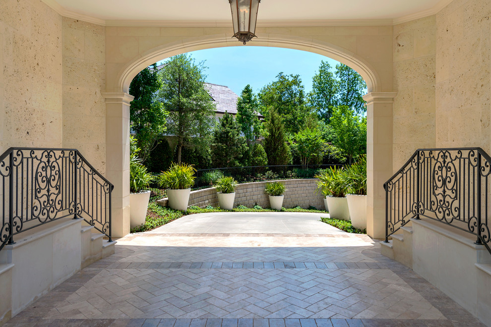 Photo of a mediterranean front yard driveway in Dallas with natural stone pavers.