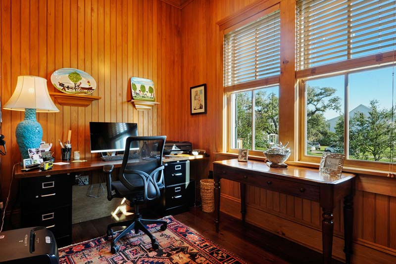 Diseño de despacho tradicional pequeño con paredes marrones, suelo de madera oscura, escritorio independiente, madera y madera