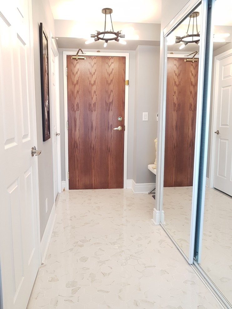 This is an example of a small modern foyer in Toronto with grey walls, porcelain floors, a single front door, a brown front door and white floor.
