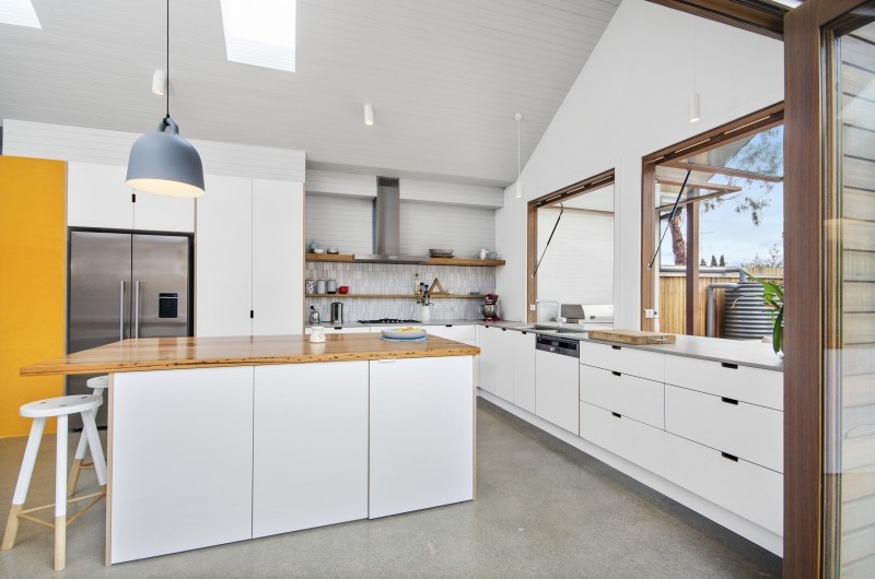 Inspiration for a mid-sized contemporary l-shaped eat-in kitchen in Other with an undermount sink, flat-panel cabinets, white cabinets, quartz benchtops, white splashback, porcelain splashback, stainless steel appliances, concrete floors and with island.