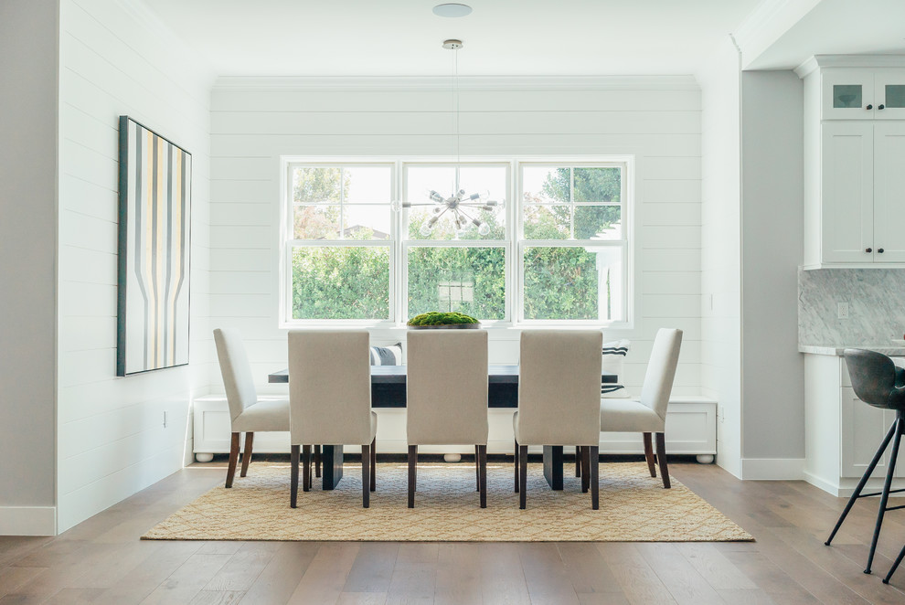 Example of a beach style medium tone wood floor kitchen/dining room combo design in Los Angeles with white walls and no fireplace