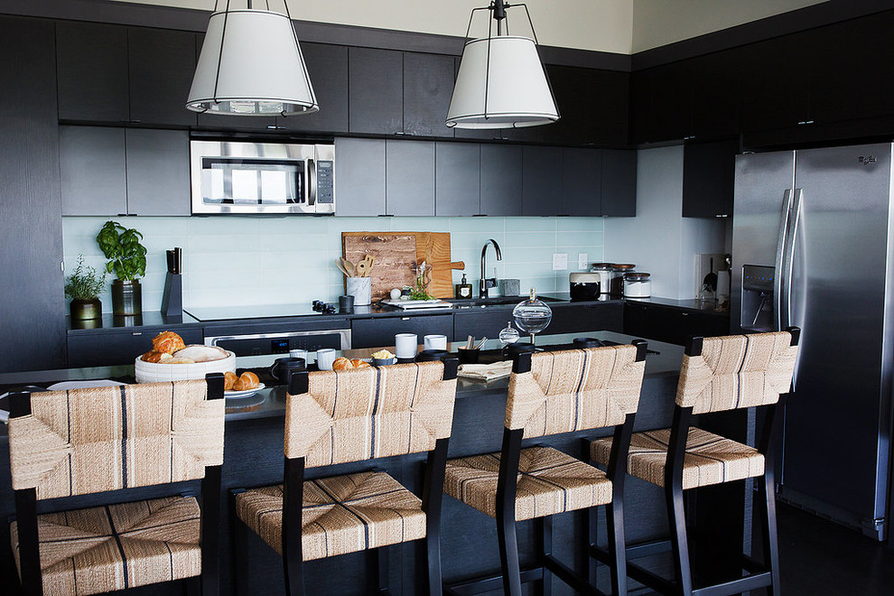Penthouse Decor in Bethesda - Open concept kitchen - mid-sized transitional l-shaped dark wood floor and black floor open concept kitchen idea in DC Metro with an undermount sink, flat-panel cabinets, black cabinets, solid surface countertops, white backsplash, glass tile backsplash, stainless steel appliances and an island
