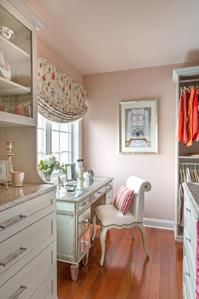 Design ideas for a mid-sized traditional women's dressing room in Philadelphia with shaker cabinets, white cabinets, medium hardwood floors and brown floor.