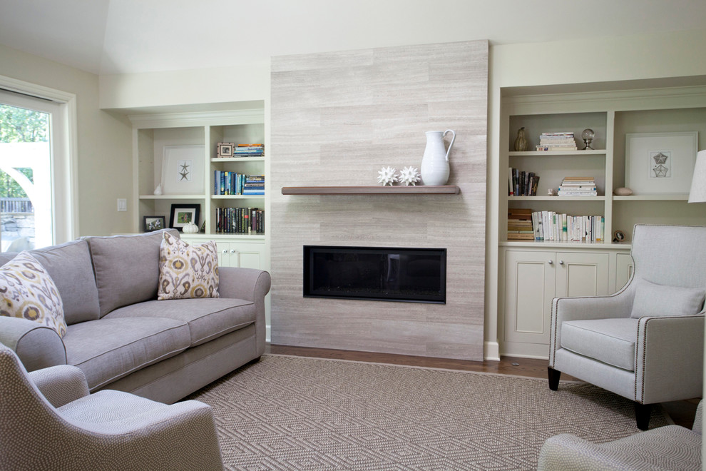 This is an example of a mid-sized transitional open concept living room in San Francisco with beige walls, medium hardwood floors, a standard fireplace, a stone fireplace surround and no tv.