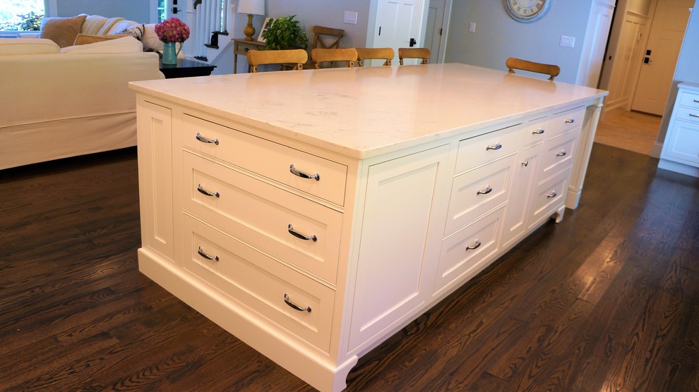 Open concept kitchen - large transitional l-shaped dark wood floor and brown floor open concept kitchen idea in Boston with a farmhouse sink, beaded inset cabinets, white cabinets, quartz countertops, white backsplash, subway tile backsplash, paneled appliances, an island and white countertops