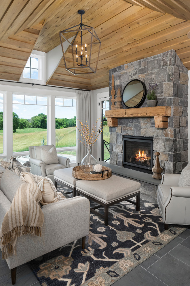 Country formal enclosed living room in Minneapolis with slate floors, a standard fireplace, a stone fireplace surround, blue floor, white walls, no tv, vaulted and wood.