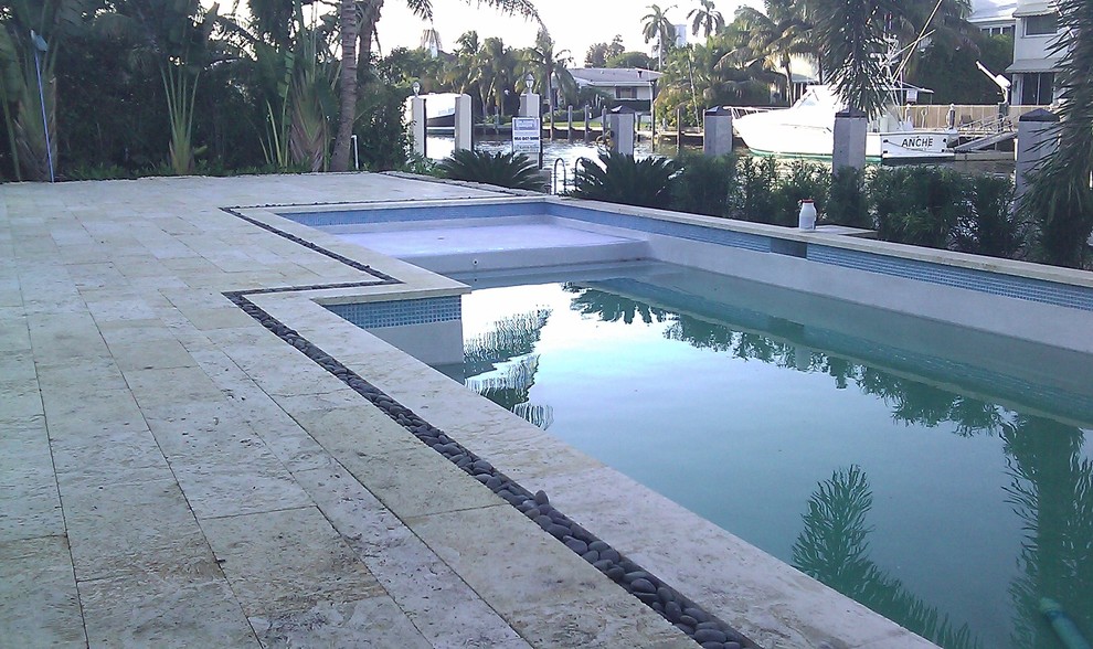 Inspiration for a mid-sized modern backyard stone and rectangular pool remodel in Miami