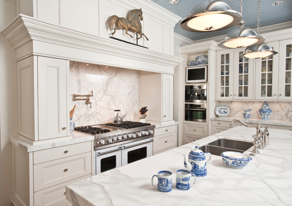 This is an example of a traditional kitchen in Indianapolis with glass-front cabinets, marble benchtops, a double-bowl sink, white cabinets, white splashback, white appliances and marble splashback.