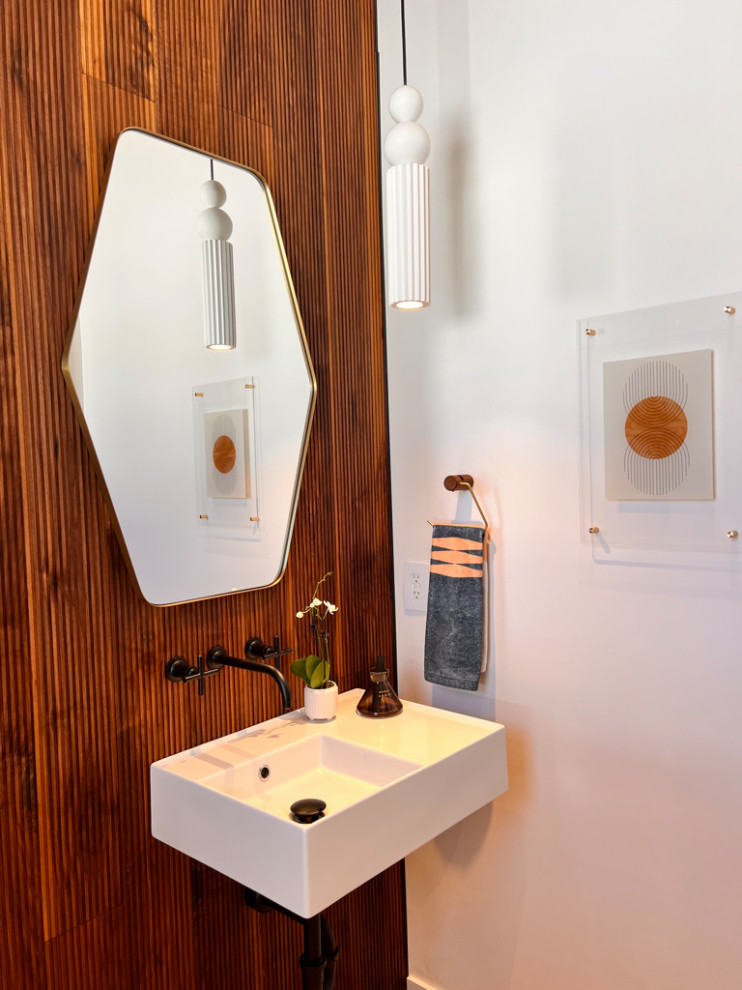 Пример оригинального дизайна: туалет с писсуаром, коричневыми стенами, полом из керамической плитки, подвесной раковиной, бежевым полом, напольной тумбой и панелями на части стены