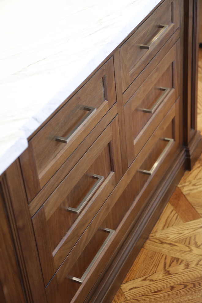 Large transitional u-shaped medium tone wood floor eat-in kitchen photo in Los Angeles with an undermount sink, recessed-panel cabinets, white cabinets, wood countertops, white backsplash, stone tile backsplash, stainless steel appliances and an island