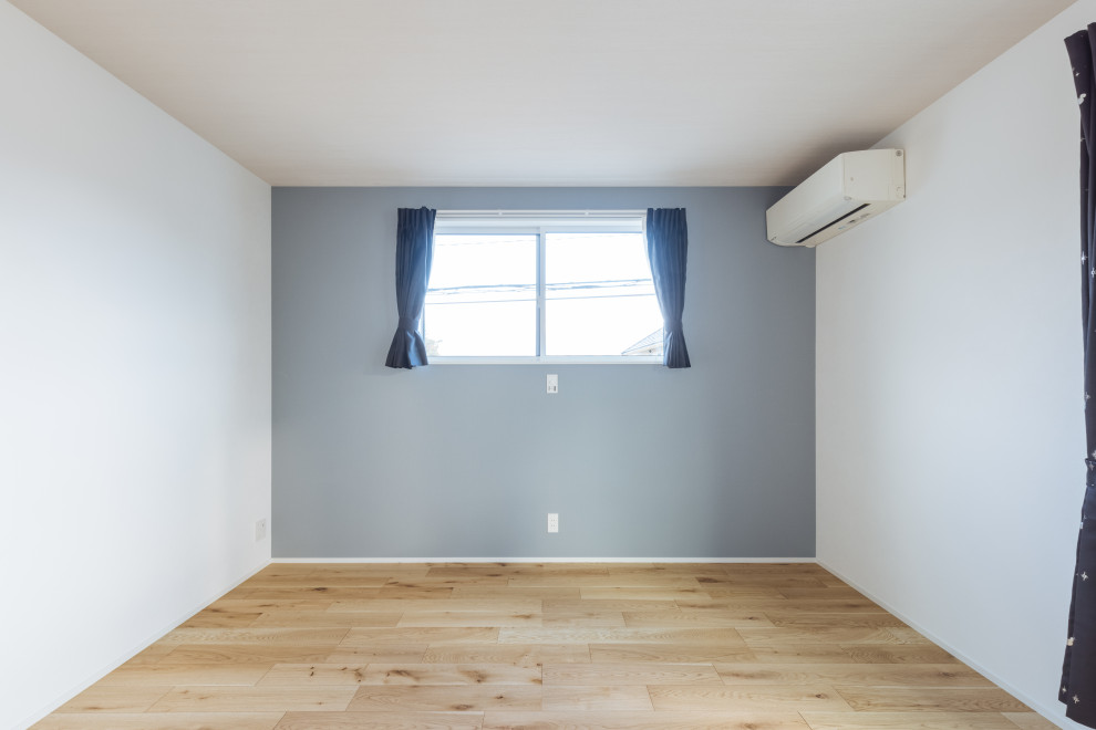 Mid-sized danish light wood floor, beige floor, wallpaper ceiling and wallpaper bedroom photo in Other with green walls