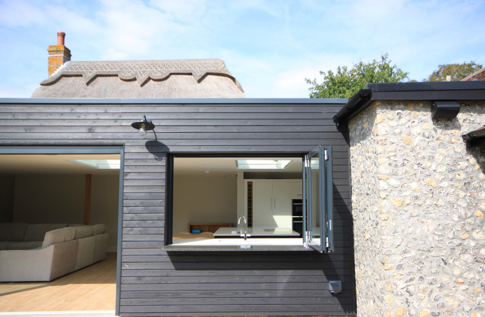 Mittelgroßes, Zweistöckiges Eklektisches Einfamilienhaus mit Mix-Fassade und schwarzer Fassadenfarbe in Sussex