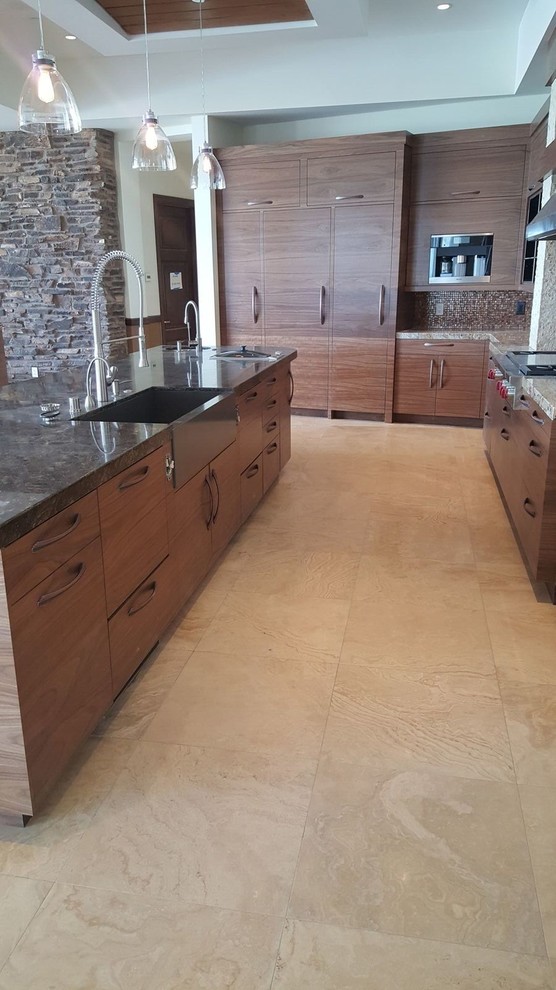 This is an example of a large contemporary l-shaped open plan kitchen in Las Vegas with a farmhouse sink, flat-panel cabinets, dark wood cabinets, granite benchtops, brown splashback, mosaic tile splashback, stainless steel appliances, ceramic floors and with island.